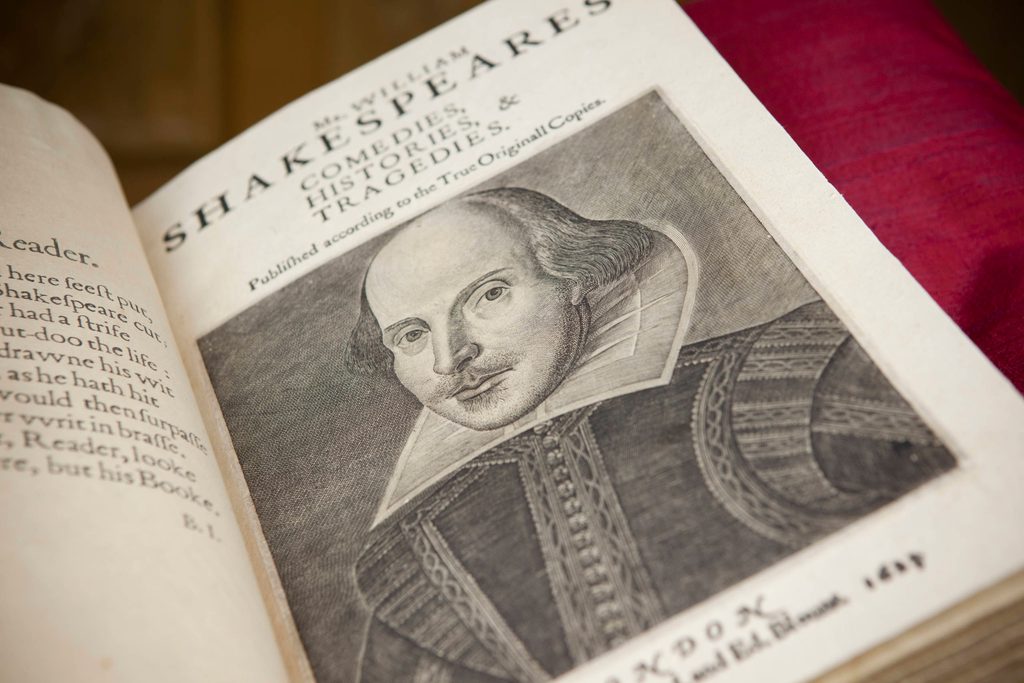 A book lies open on its title page, with an engraving of a picture of a man