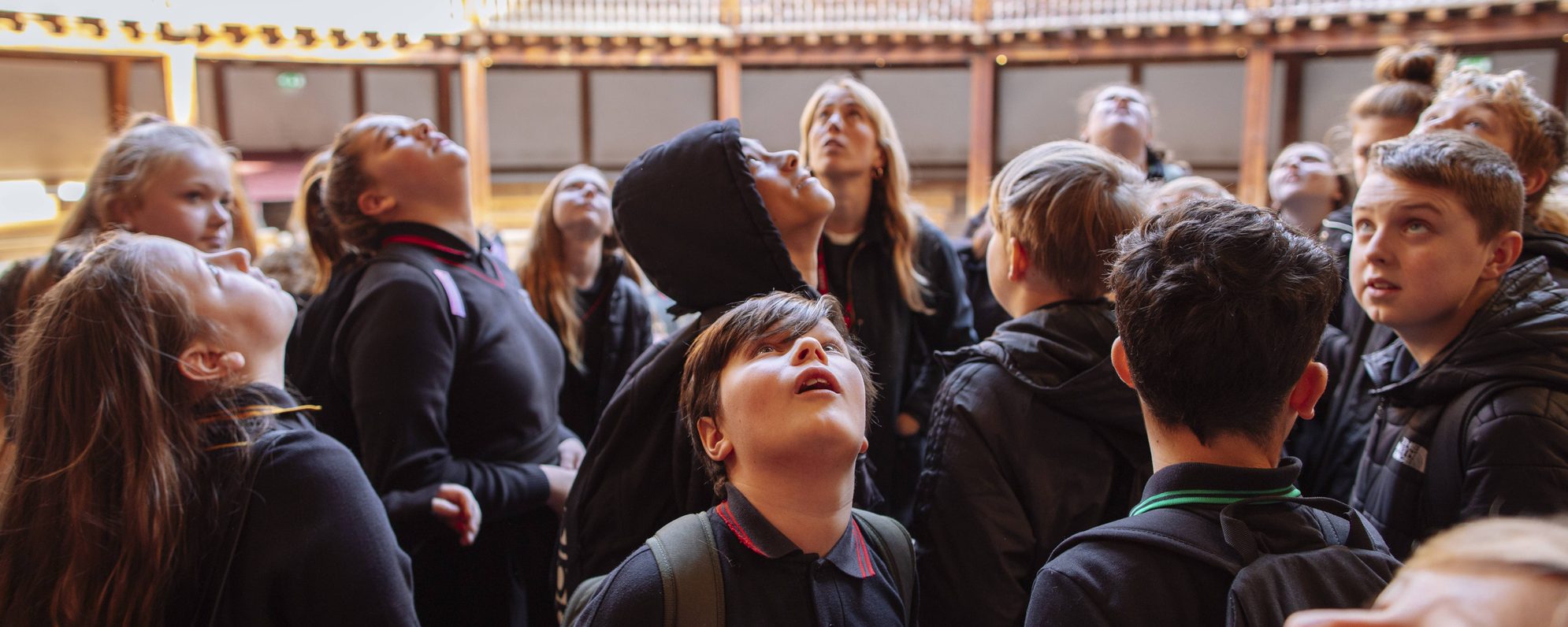 Group of school children in the Globe, gazing up in awe